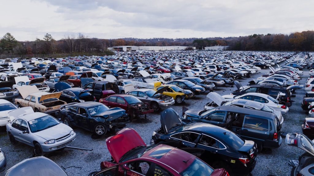 Wide view of a large car junkyard in Chattanooga with numerous vehicles showing signs of wear.