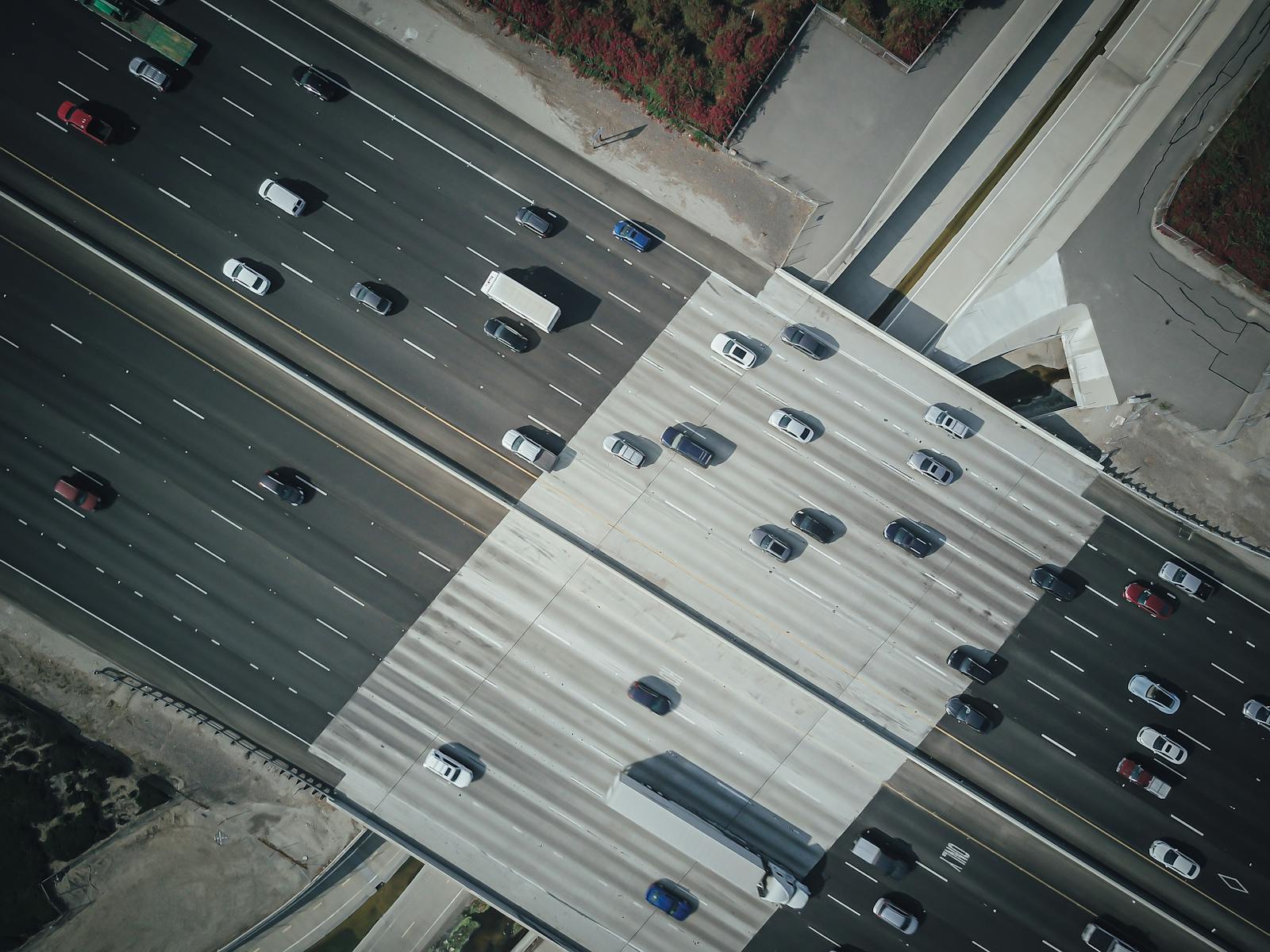 High angle aerial shot capturing vehicles commuting on a busy highway.