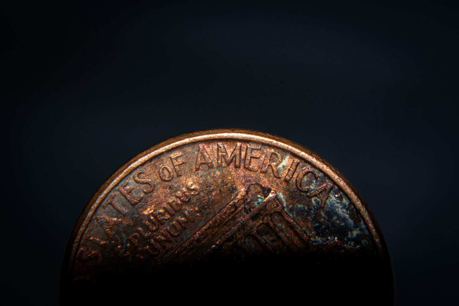 a close up of a penny on a black background