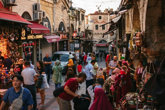a crowd of people walking through a busy street