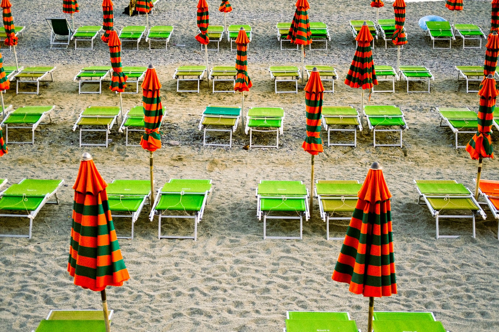 a beach with many chairs and umbrellas