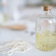 Artisan candle crafting scene with a glass bottle, wick, and aromatic wax ingredients.
