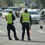 two police officers standing on the side of a road