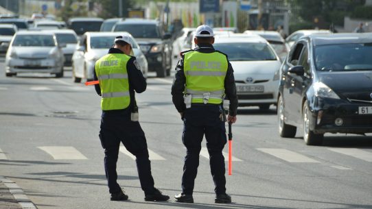 two police officers standing on the side of a road