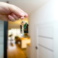 Holding house keys in front of the entrance.