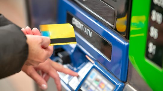 a person using a credit card to pay for a machine
