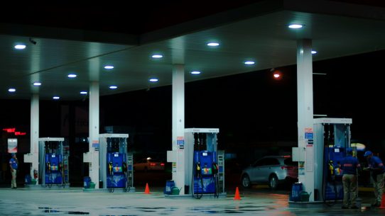 person taking a photo of blue and white gasoline station
