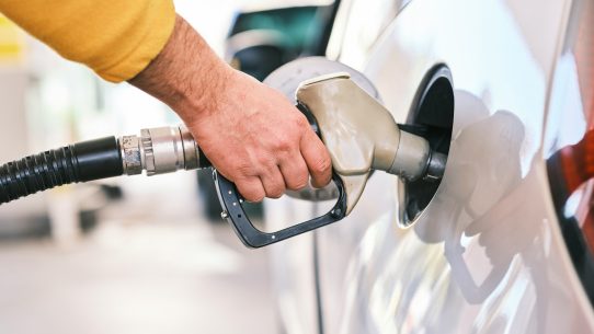 a man pumping gas into his car at a gas station