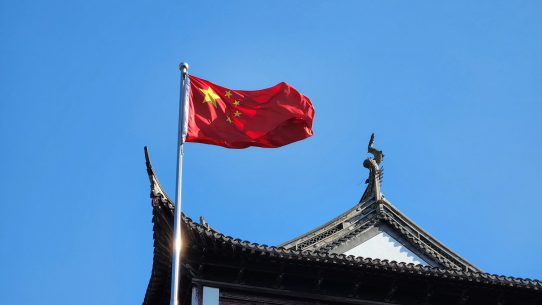 A chinese flag flying on top of a building