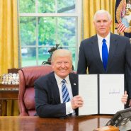 2 men in black suit sitting on red chair