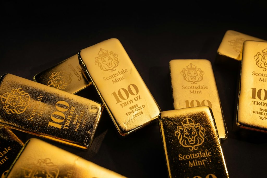 Several gold bars scattered on a dark surface.