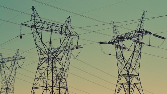 black transmission towers under green sky