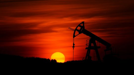 oil pump jack silhouette against red sunset
