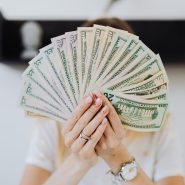 Close-up of hands holding a fan of US dollar bills, showcasing financial abundance.