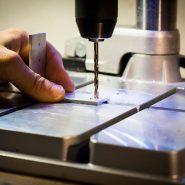 person drilling metal bar