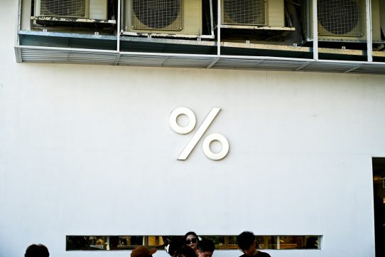 White wall with a large percent sign logo