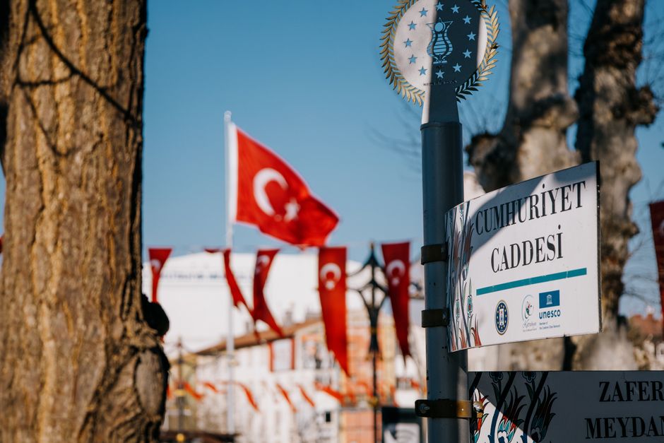Cumhuriyet Caddesi street sign with Turkish flags in Kütahya, Türkiye.