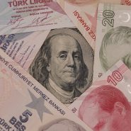 a pile of different currency sitting on top of each other