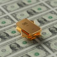 a gold bar sitting on top of a pile of money